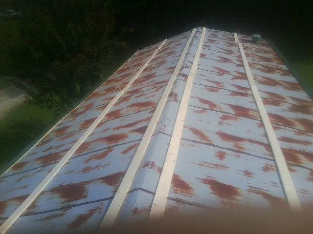 Rusted metal roof panels with new wood purlins before replacement — Storm Damage Roof Repair in Piketon by Roofing Brothers