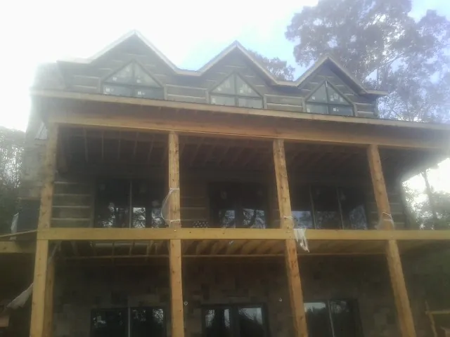 Dormers and porch framing on a large log home under construction — Roof Coating work by our crew in Piketon