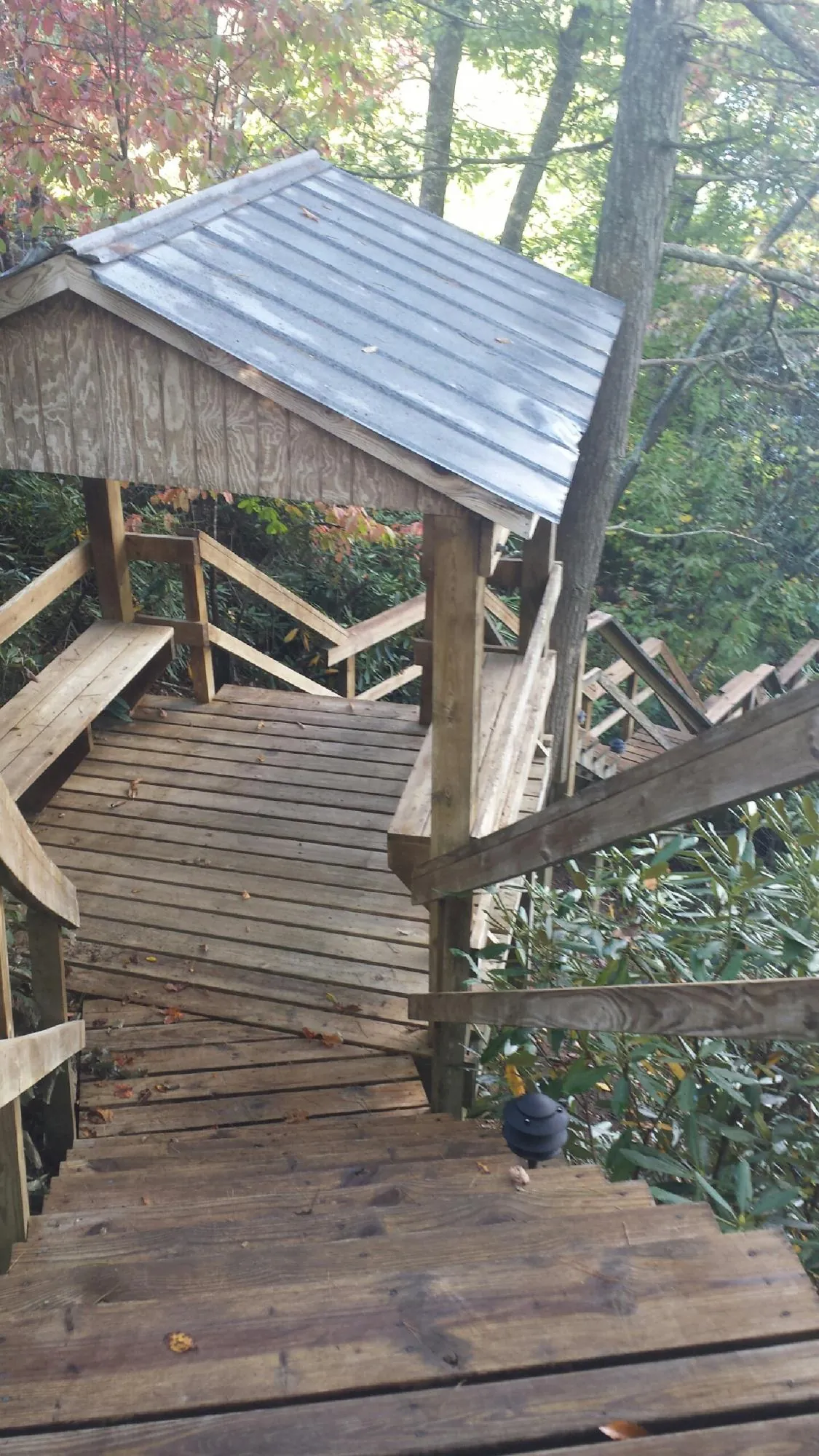 Metal roofed shelter over wooden steps on a wooded walkway — Skylight Repair & Installation work by our crew in Piketon