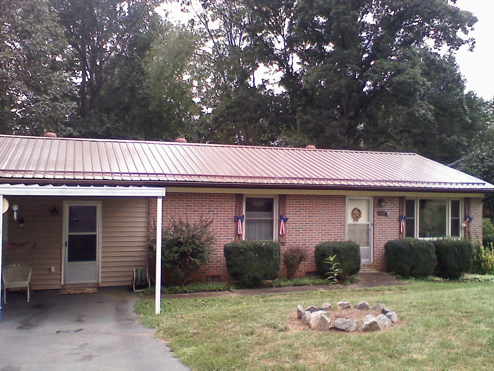 Bronze metal roof and carport on a brick ranch home — Roof Repair work by our crew in Piketon